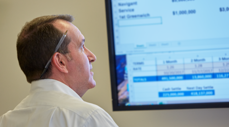 Money Desk manager reviewing information and rates on screen