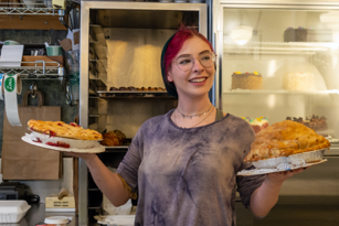 woman standing with a pie in each hand