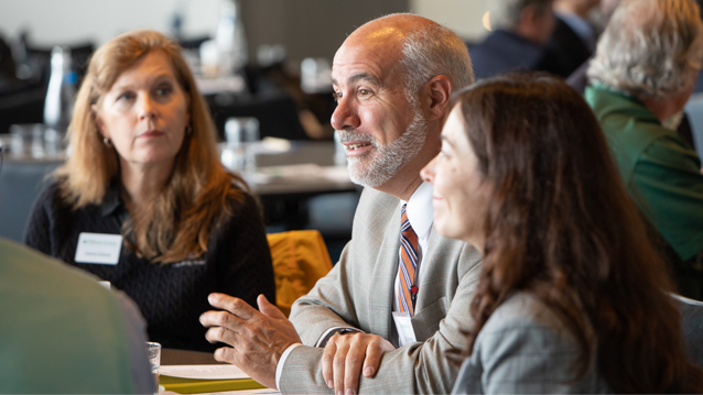 man sitting at table with two women sitting on either side of him