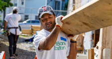 man holding a large piece of plywood