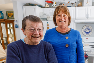 senior female affordable housing resident standing next to female banking professional